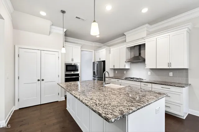 a kitchen with kitchen island granite countertop a stove and a sink