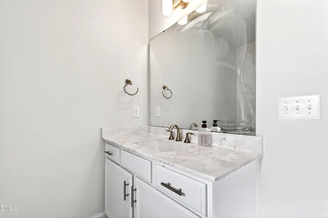a bathroom with a granite countertop sink and a mirror