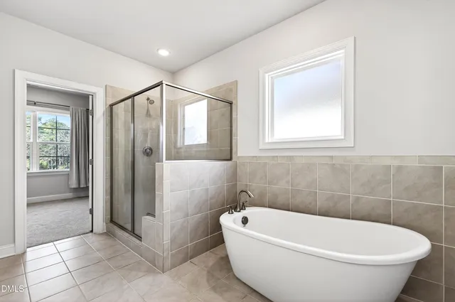 a white bath tub sitting in a bathroom next to a window