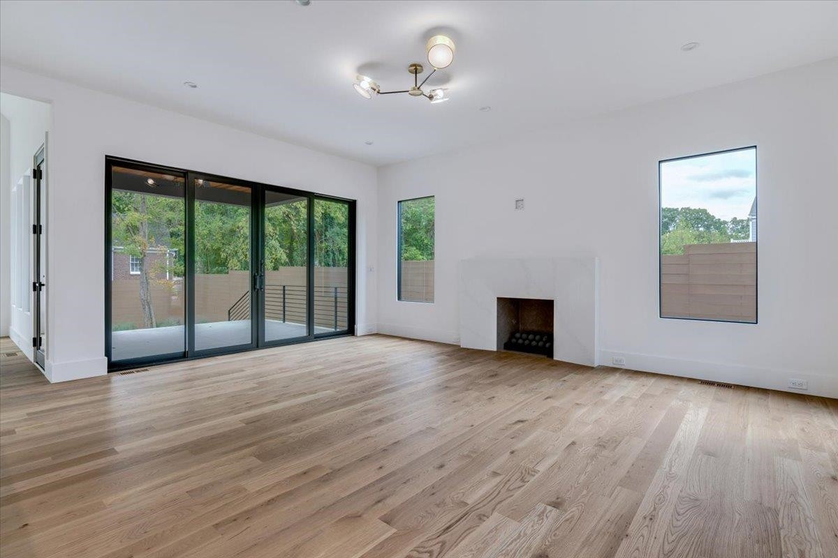 807 Chamberlain Street Raleigh, NC 27607 - Photo 24 of 40 a view of an empty room with a window and wooden floor