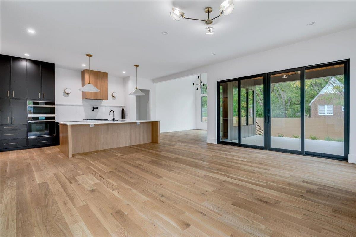 807 Chamberlain Street Raleigh, NC 27607 - Photo 25 of 40 a view of a kitchen with a stove cabinets and a wooden floor