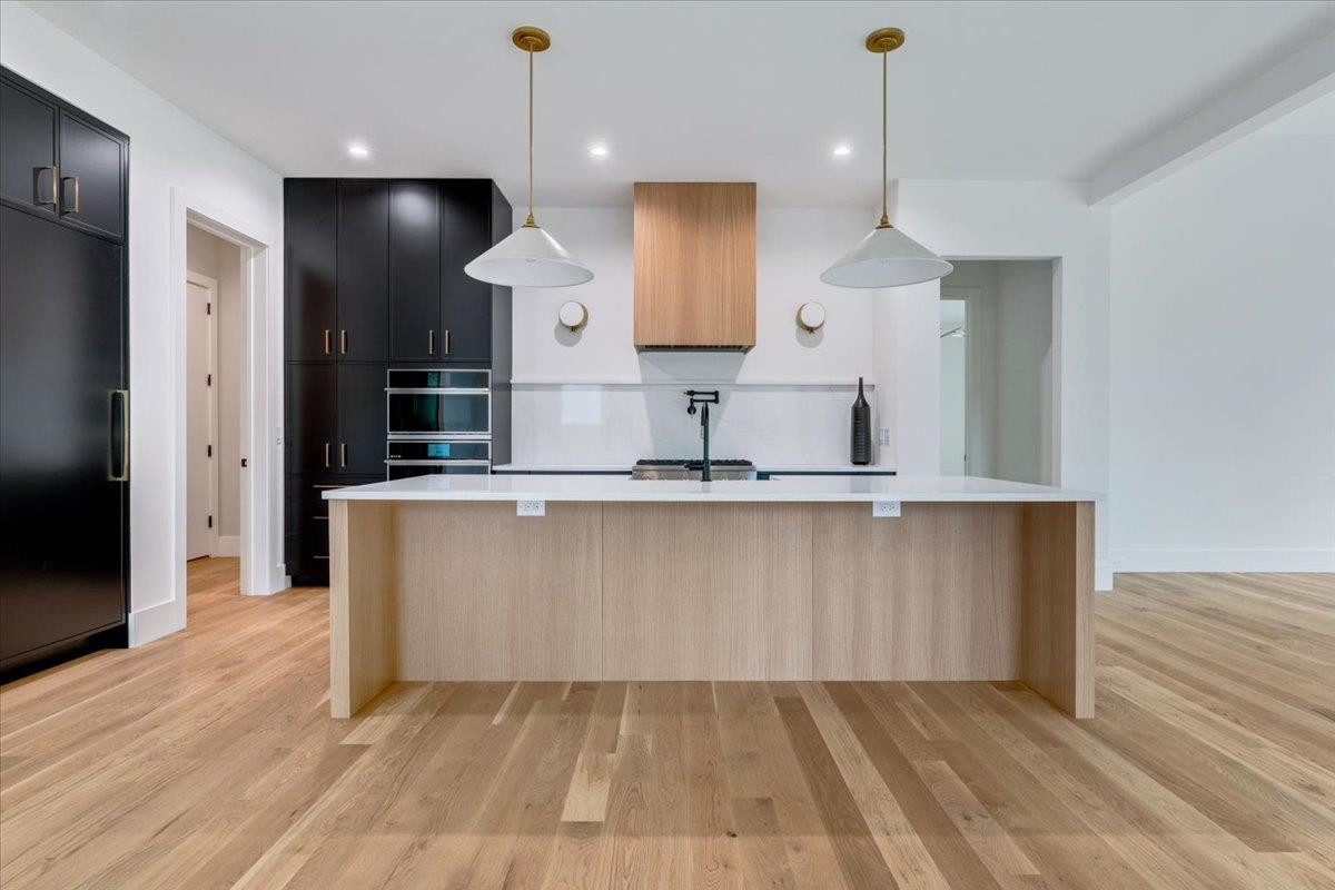 807 Chamberlain Street Raleigh, NC 27607 - Photo 33 of 40 a large kitchen with stainless steel appliances a large counter top a refrigerator a sink and a oven