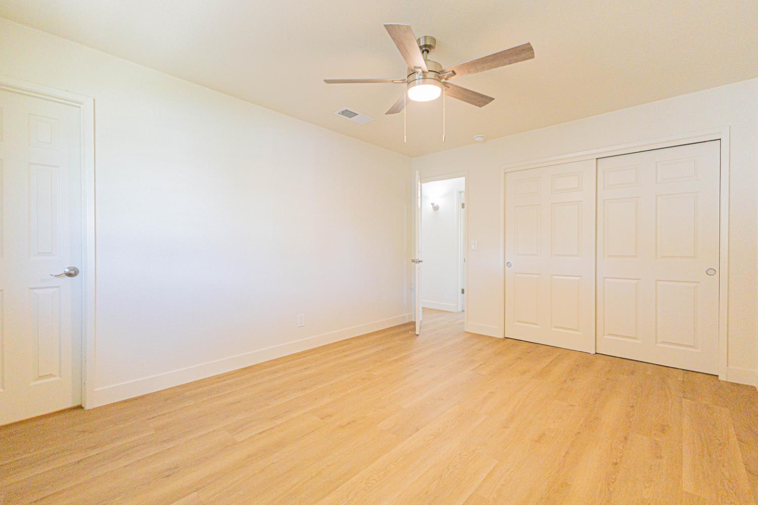 17925 Rodeo Drive Madera, CA 93638 - Photo 19 of 26 an empty room with wooden floor and fan