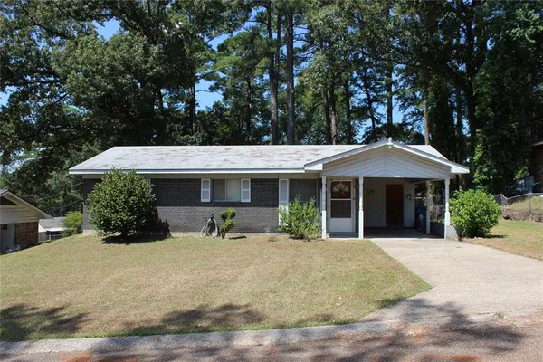 a front view of a house with yard and trees