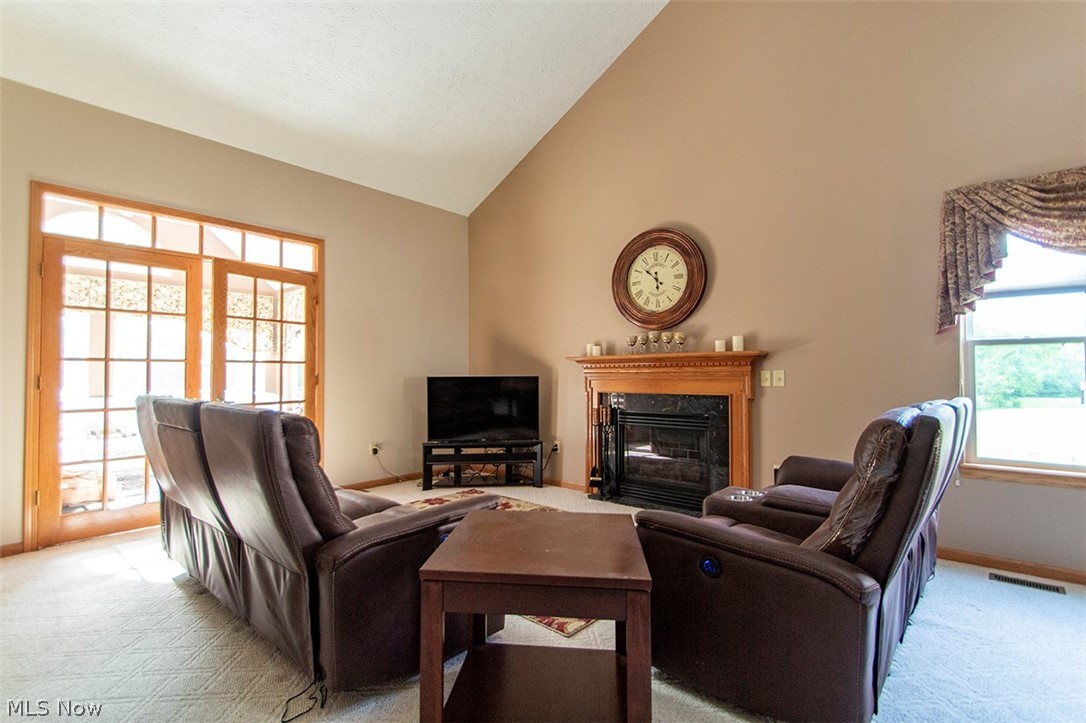 4902 Foote Road, Unit 21 Medina, OH 44256 - Photo 9 of 34 Great room featuring a wealth of natural light, high vaulted ceiling, and light colored carpet