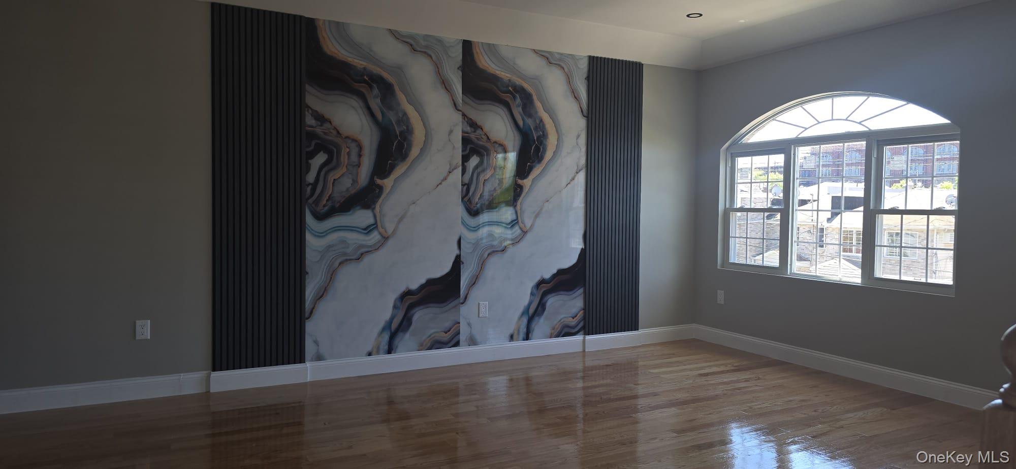 108-33 164th Street Queens, NY 11433 - Photo 5 of 20 an empty room with wooden floor and windows