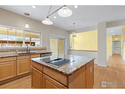 a kitchen with kitchen island granite countertop a stove and a sink