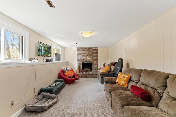 a living room with furniture fireplace and window