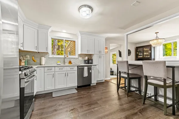 a kitchen with a refrigerator a stove a dining table and chairs