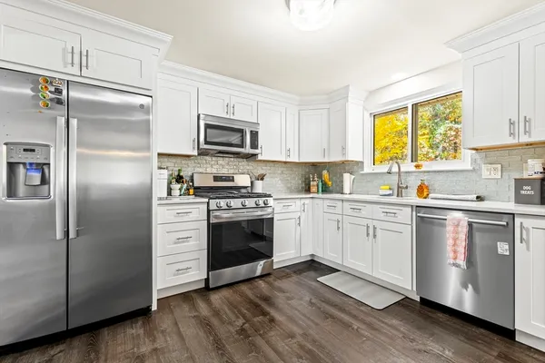 a kitchen with granite countertop a refrigerator stove and sink