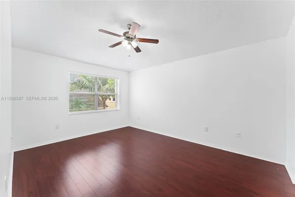 a view of empty room with wooden floor