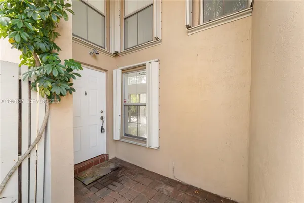 a view of a white house with a small yard and sitting area