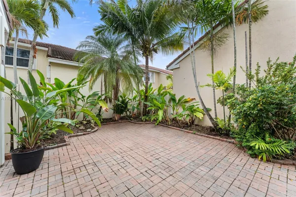 a view of a house with a yard and palm trees