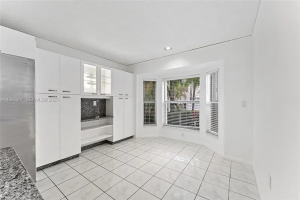 a view of empty room with kitchen