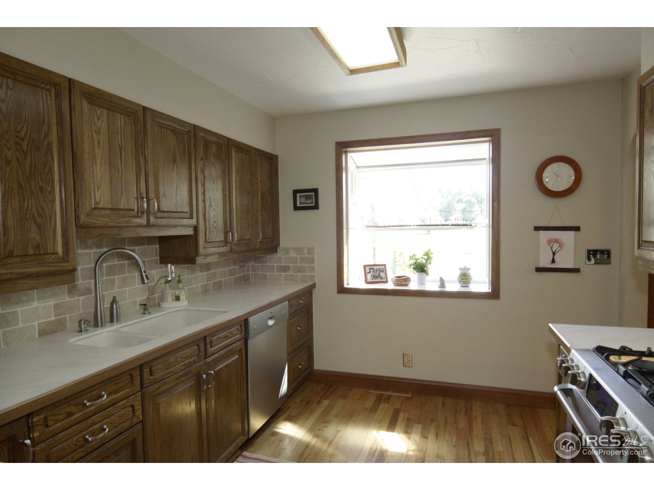 1084 Gapter Road Boulder, CO 80303 - Photo 9 of 25 a kitchen with granite countertop a stove a sink dishwasher and cabinets with wooden floor