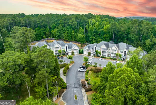 an aerial view of residential houses with outdoor space and trees
