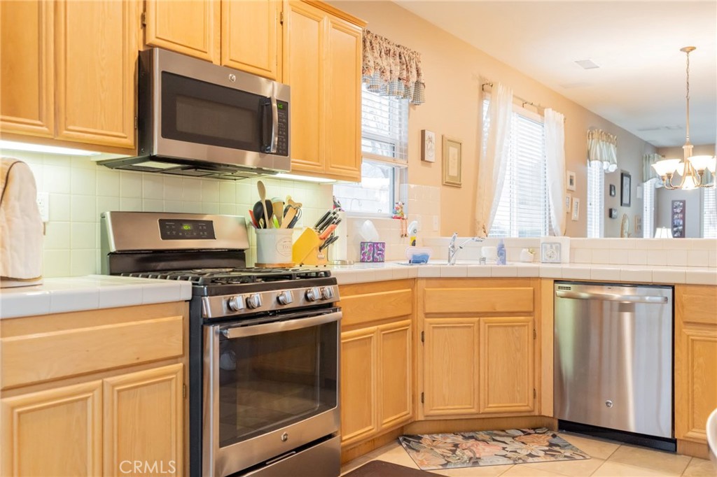 11555 Townsend Way Yucaipa, CA 92399 - Photo 13 of 47 a kitchen with stainless steel appliances granite countertop a stove a sink and a microwave