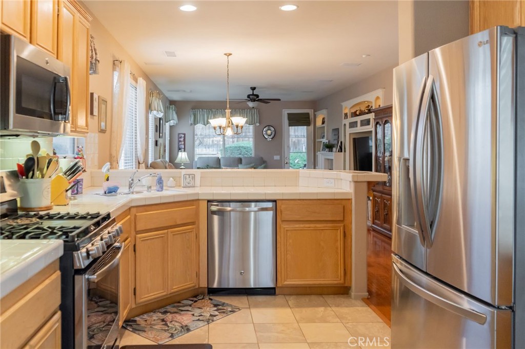 11555 Townsend Way Yucaipa, CA 92399 - Photo 15 of 47 a kitchen with stainless steel appliances granite countertop a refrigerator a oven and white cabinets with wooden floors