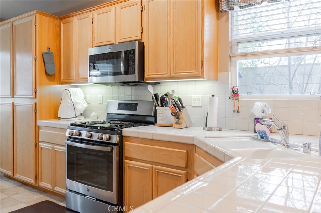 11555 Townsend Way Yucaipa, CA 92399 - Photo 16 of 47 a kitchen with stainless steel appliances granite countertop a stove a sink and a microwave
