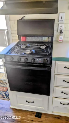 a stove top oven sitting inside of a kitchen