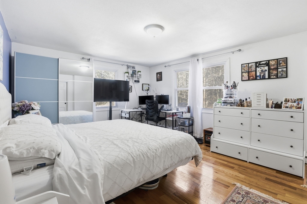 97 Chicopee Row Groton, MA 01450 - Photo 26 of 41 a bedroom with a large bed and a flat tv screen on dresser