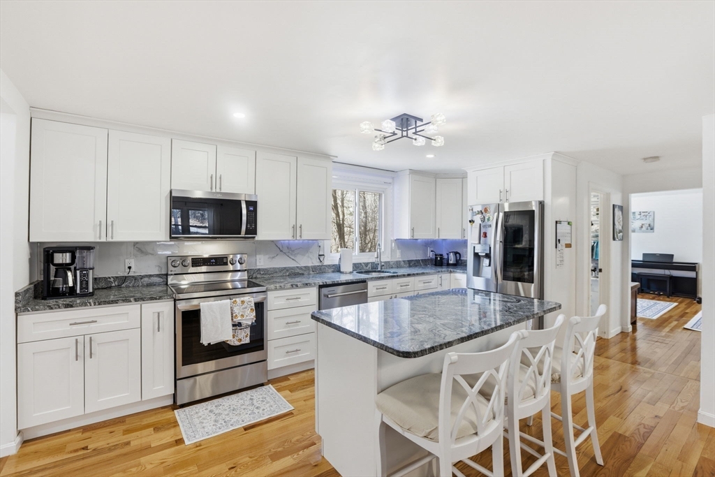 97 Chicopee Row Groton, MA 01450 - Photo 8 of 41 a kitchen with stainless steel appliances granite countertop a sink stove and refrigerator