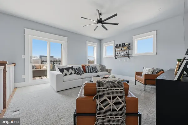 a living room with furniture a ceiling fan and a window