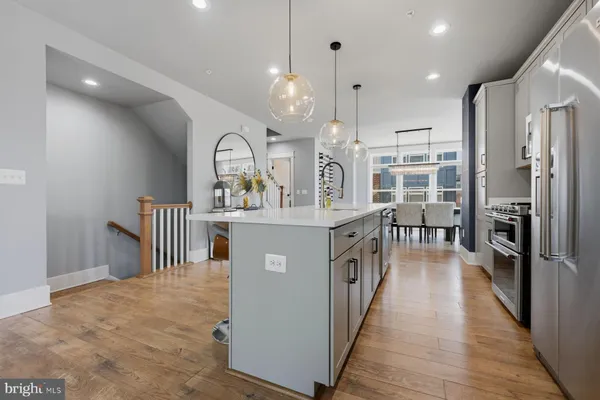 a kitchen with stainless steel appliances kitchen island granite countertop a refrigerator a stove top oven and a sink