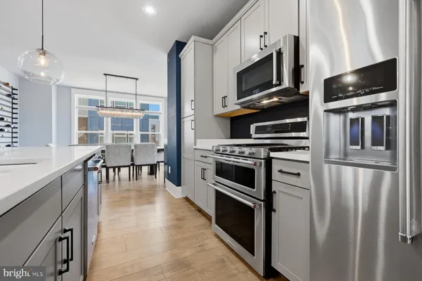 a kitchen with stainless steel appliances a stove microwave and a refrigerator