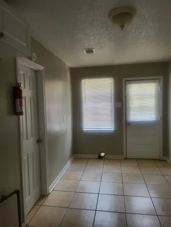 a view of an empty room with a kitchen and a sink