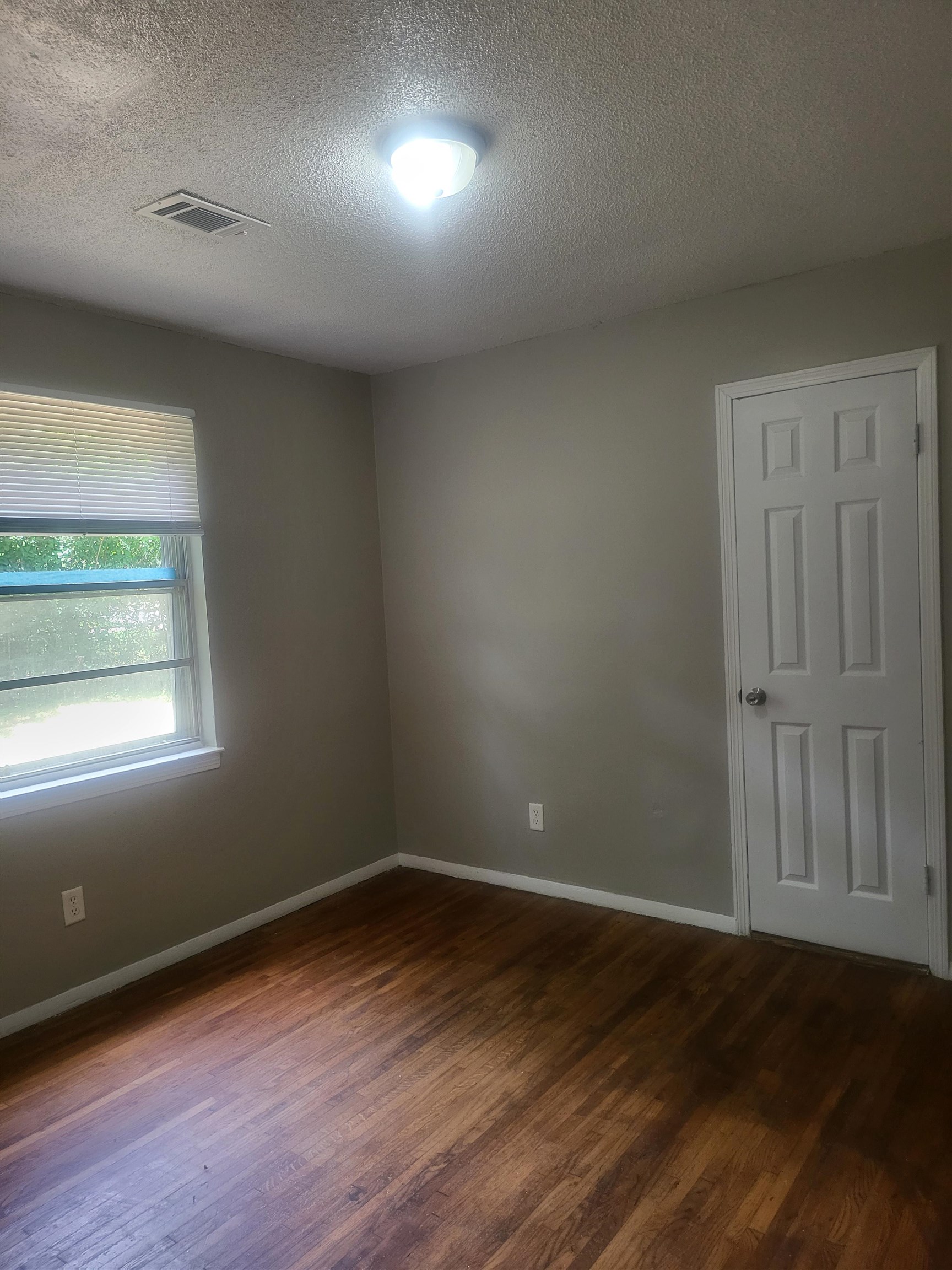 3705 Suzanne Drive Memphis, TN 38127 - Photo 7 of 10 an empty room with wooden floor and windows