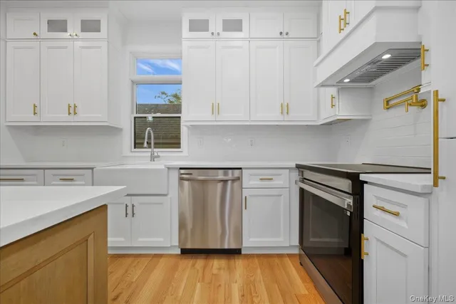 a kitchen with white cabinets and stainless steel appliances