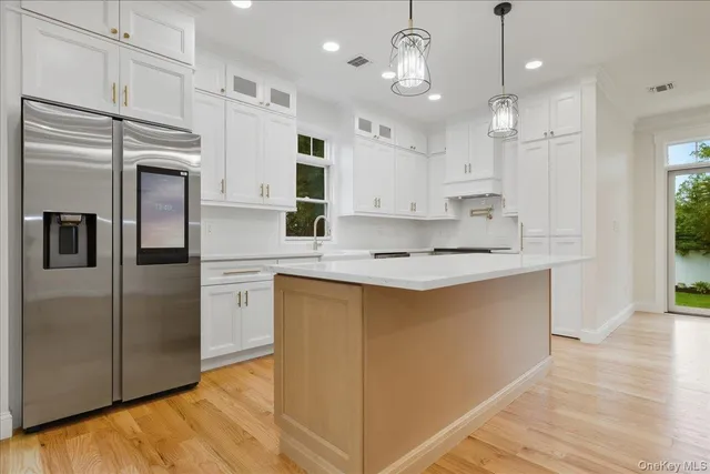 a kitchen with stainless steel appliances granite countertop a stove a sink and white cabinets