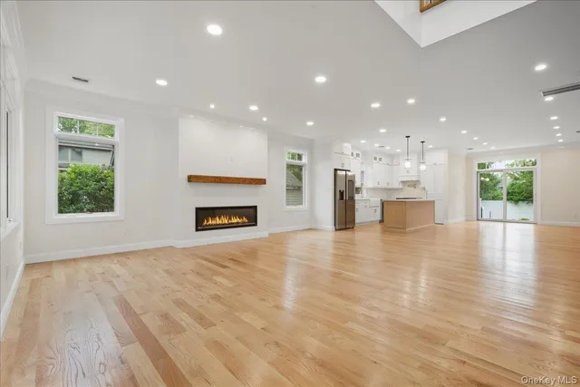 a view of an empty room and a kitchen