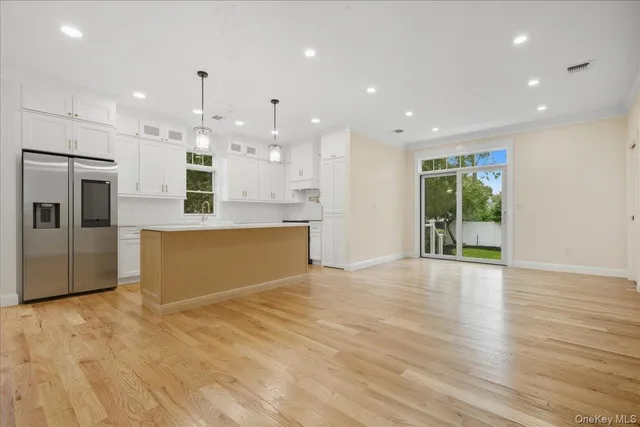 a large kitchen with stainless steel appliances kitchen island wooden cabinets and a granite counter tops