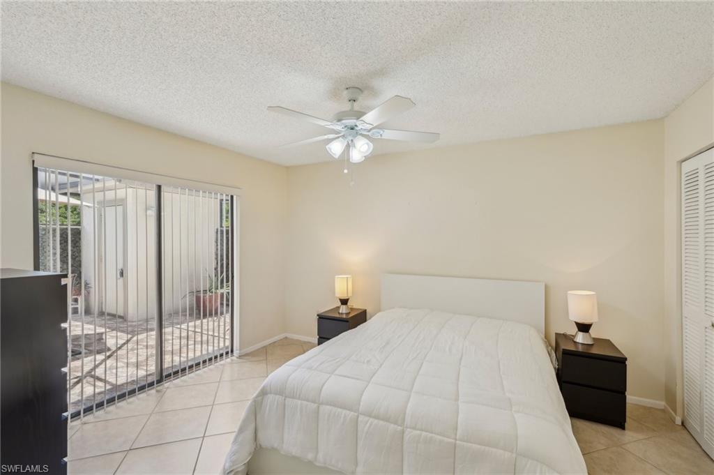 13345 Broadhurst Loop Fort Myers, FL 33919 - Photo 18 of 33 Bedroom with access to exterior, light tile patterned flooring, a textured ceiling, ceiling fan, and a closet