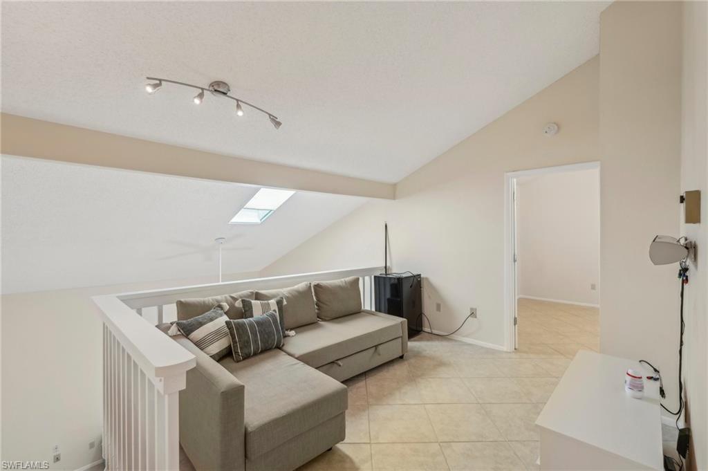 13345 Broadhurst Loop Fort Myers, FL 33919 - Photo 22 of 33 Living area with a skylight, vaulted ceiling, and light tile patterned floors