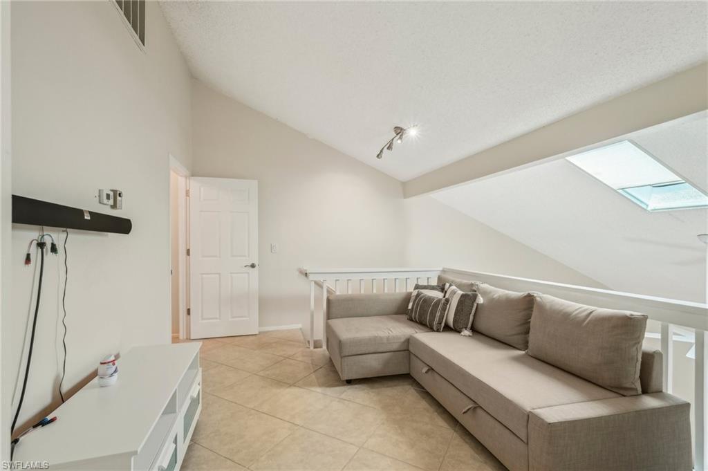 13345 Broadhurst Loop Fort Myers, FL 33919 - Photo 23 of 33 Living area featuring a skylight, vaulted ceiling, and light tile patterned floors