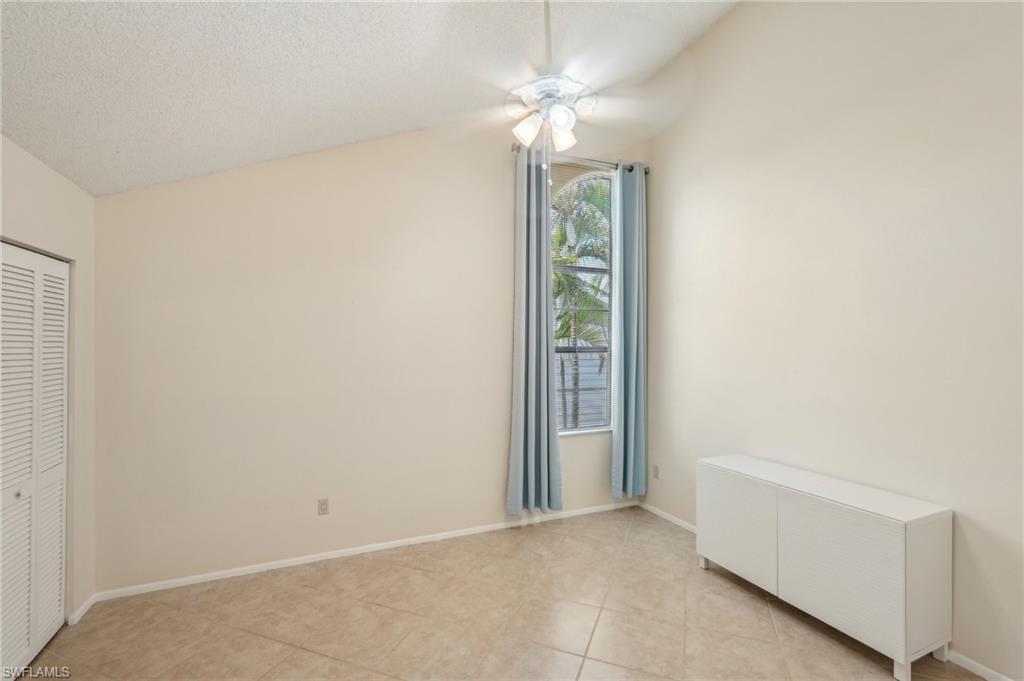 13345 Broadhurst Loop Fort Myers, FL 33919 - Photo 24 of 33 Unfurnished bedroom with vaulted ceiling, a closet, light tile patterned flooring, a textured ceiling, and ceiling fan