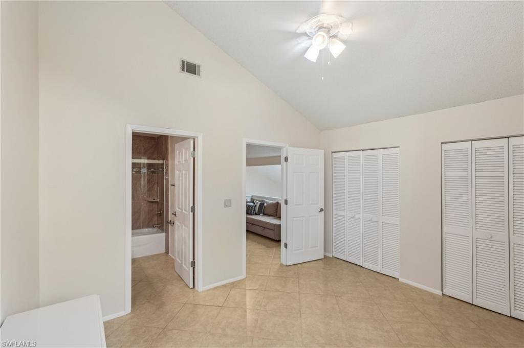 13345 Broadhurst Loop Fort Myers, FL 33919 - Photo 25 of 33 Unfurnished bedroom featuring multiple closets, high vaulted ceiling, connected bathroom, and ceiling fan