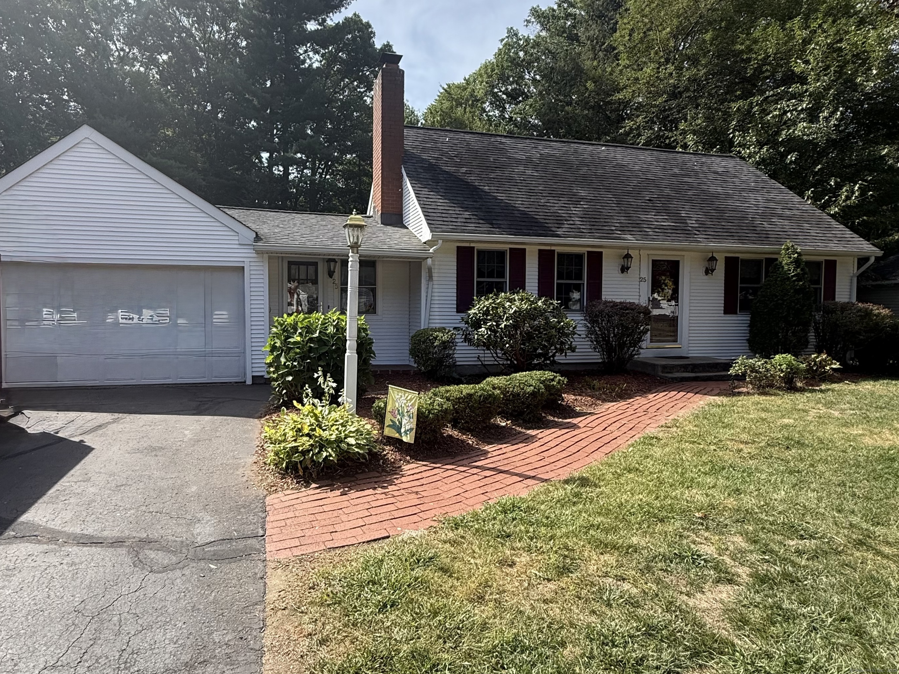 a front view of a house with a yard and potted plants