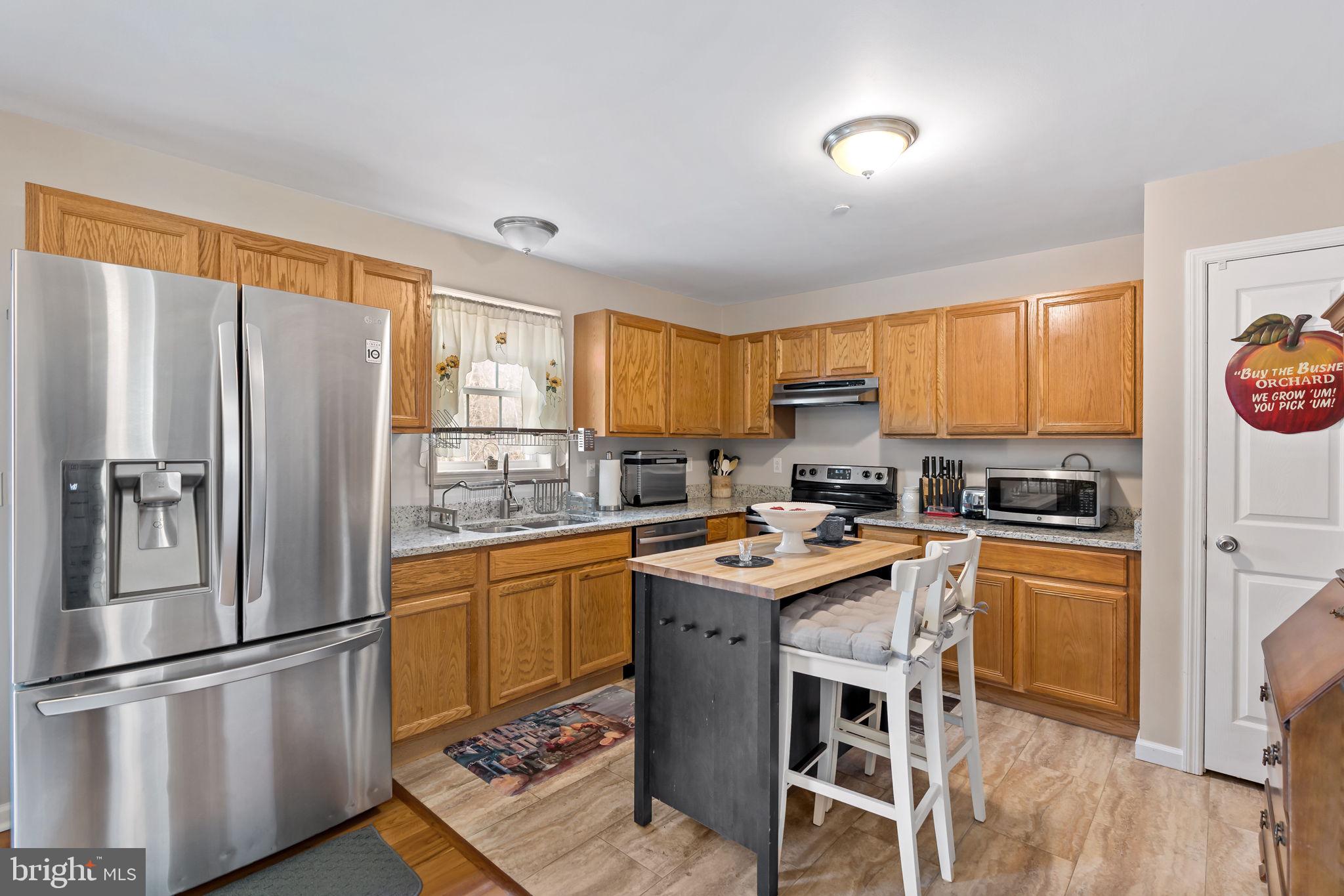 5632 Hines Road Frederick, MD 21704 - Photo 15 of 44 a kitchen with stainless steel appliances granite countertop a refrigerator a stove a sink dishwasher and white cabinets with wooden floor