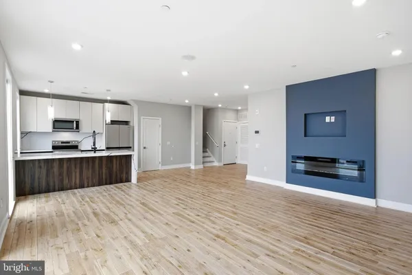 a view of a hallway with wooden floor and a washer dryer