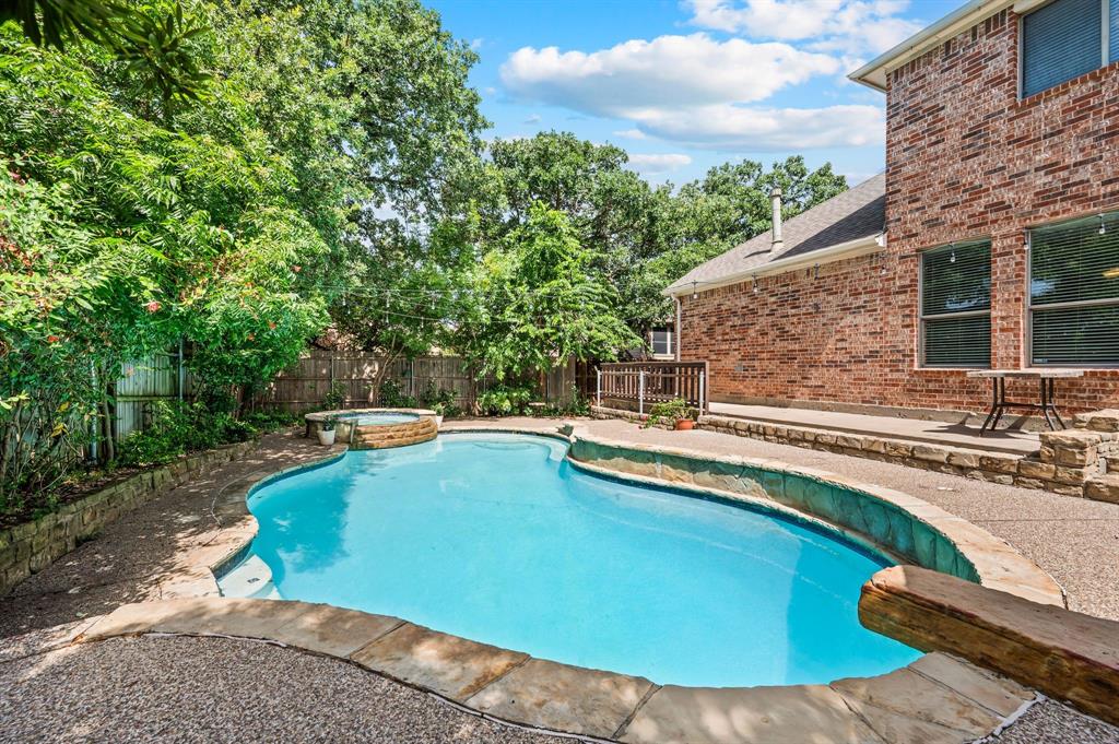 808 Briar Ridge Drive Keller, TX 76248 - Photo 39 of 40 Inviting backyard featuring a freeform swimming pool with integrated spa, a stone coping perimeter, and a concrete patio