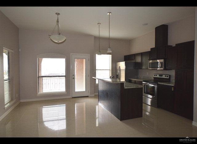 2705 Mimosa Street, Unit 4 Mission, TX 78574 - Photo 8 of 24 a kitchen with stainless steel appliances kitchen island granite countertop a refrigerator a sink dishwasher a stove and a refrigerator