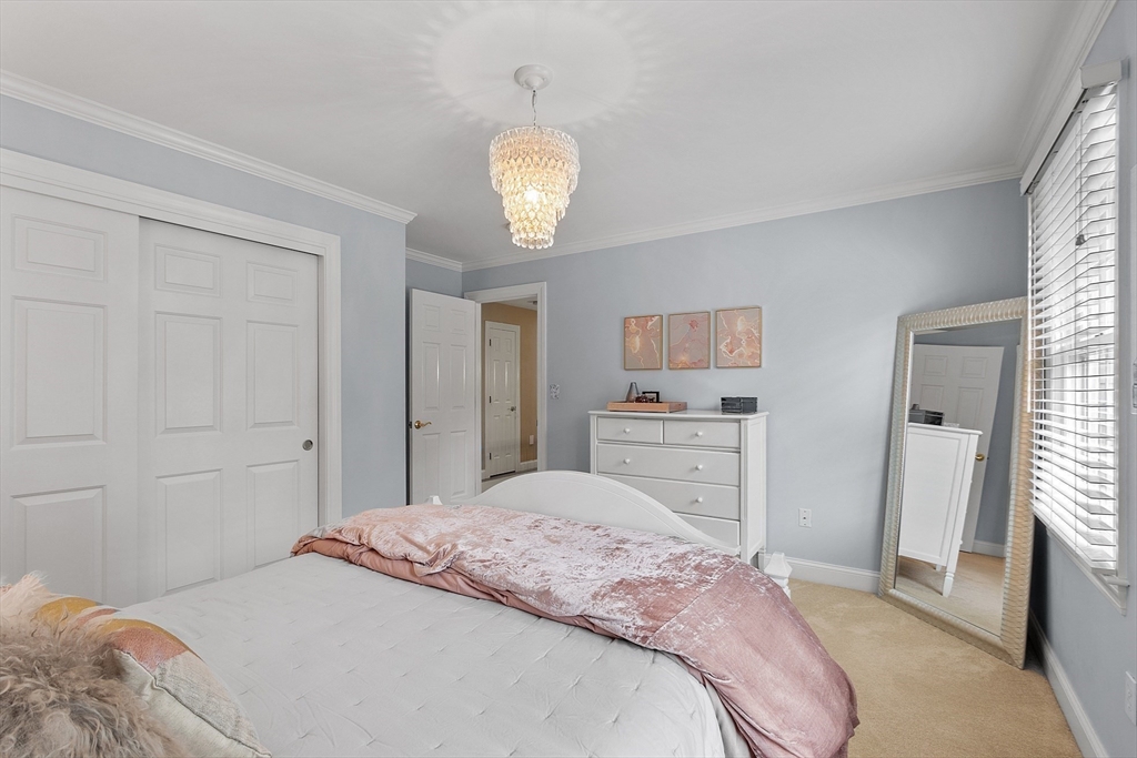 3 Coderre Way Andover, MA 01810 - Photo 34 of 42 a bedroom with a bed and a chandelier