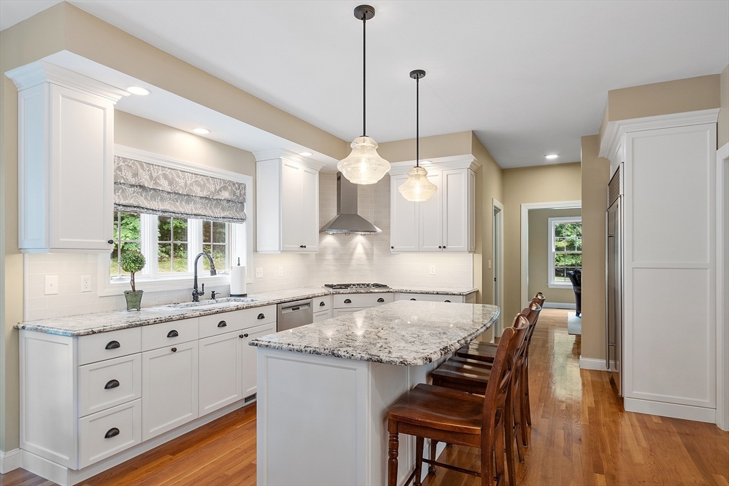 3 Coderre Way Andover, MA 01810 - Photo 8 of 42 a kitchen with granite countertop a stove a sink a dining table and chairs