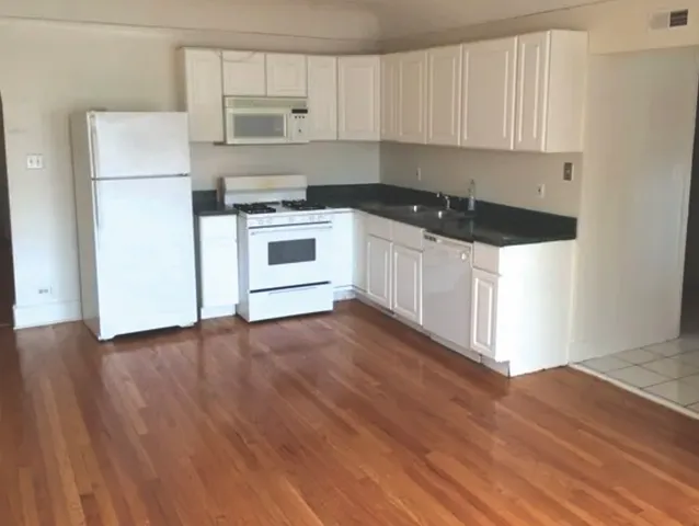 a kitchen with a refrigerator and a stove top oven