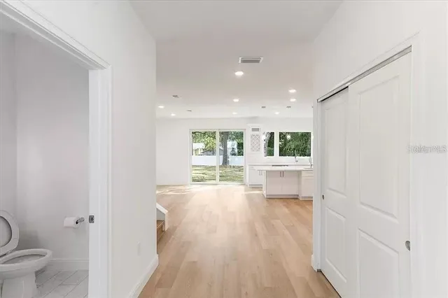 a view of a big room with wooden floor and windows