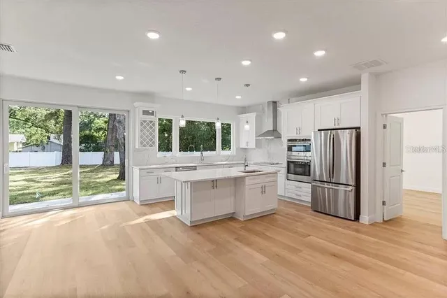 a kitchen with stainless steel appliances granite countertop a refrigerator and a sink